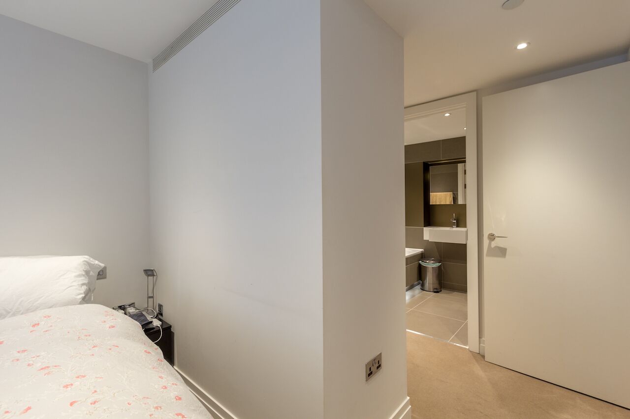 Une chambre à coucher avec un lit, une table de chevet et une commode.