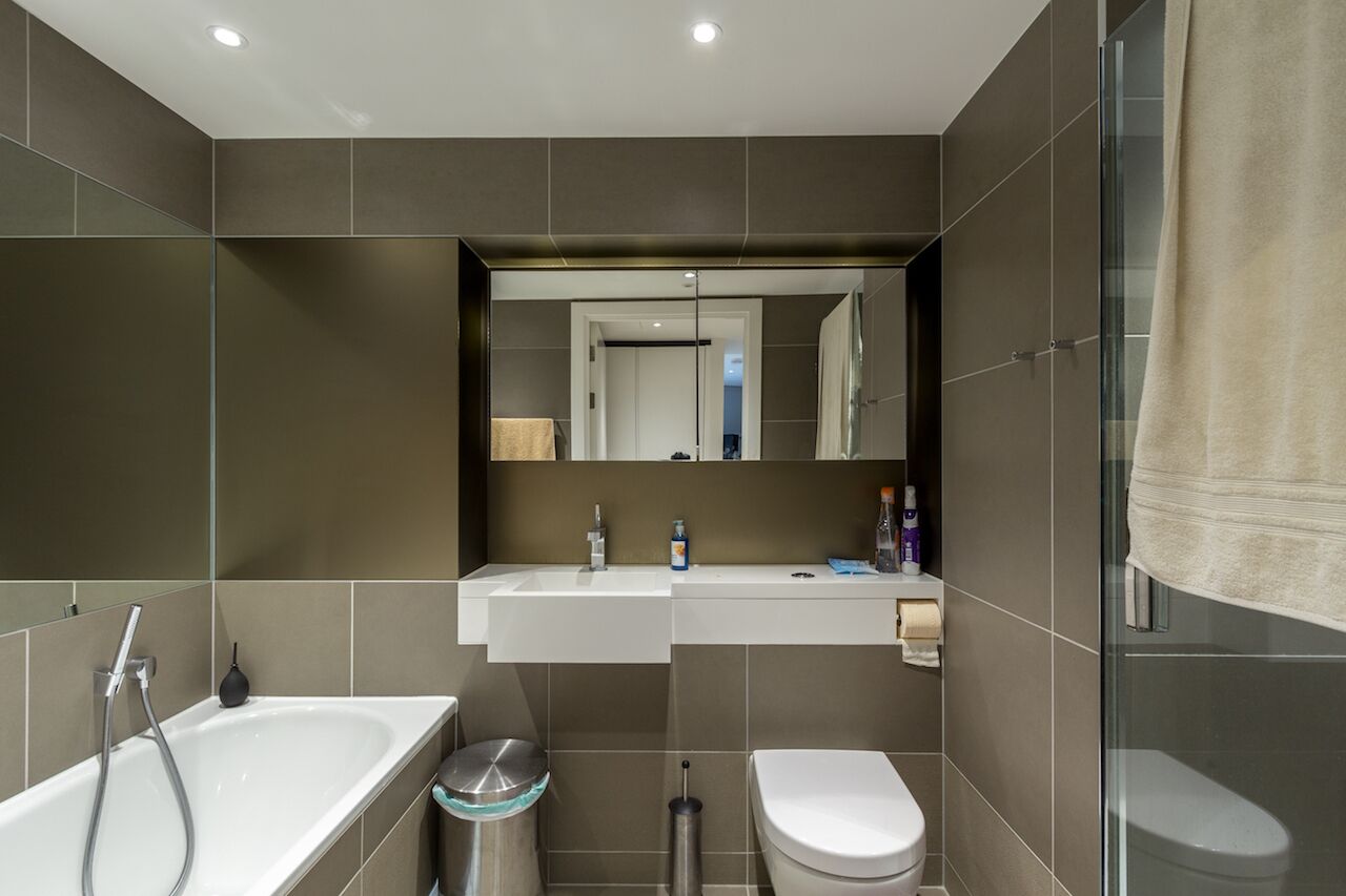 Ein modernes Badezimmer mit Badewanne, Toilette und einer Duschkabine aus Glas.