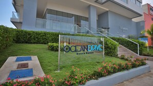 Een modern gebouw met een bord waarop staat 'OCEAN DRIVE Beach House'.