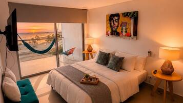 Un dormitorio moderno con una cama grande, una hamaca, un televisor y un cuadro.