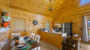 L’intérieur d’une cabane en bois comprend un coin repas, une cuisine et un petit bar.