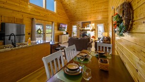 L’intérieur d’une cabane en bois comprend un coin repas, une cuisine et un salon.