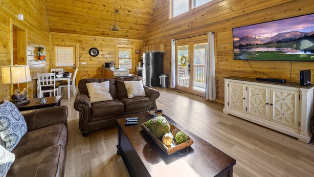 L’intérieur d’un chalet en bois comprend un salon, un coin repas et une cuisine.