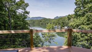 Une terrasse en bois offrant une vue sur un lac et des montagnes.