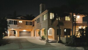 A two-story house with a garage, arched walkways, and a well-lit entrance. - Carlsbad Village, Great Beach Access, Shops & Restaurants (Carlsbad)