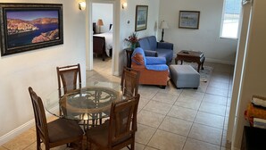 A spacious living room with a dining area, a ceiling fan, and a large window. - Carlsbad Village, Great Beach Access, Shops & Restaurants (Carlsbad)