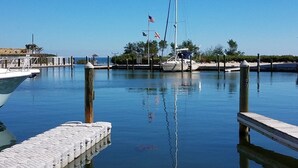 A marina with boats docked, calm water, and a clear sky.