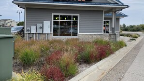Un bâtiment sur lequel est apposée une enseigne indiquant « Biggy Coffee, service au volant ».