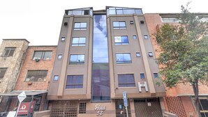 A multi-story hotel with a modern design, featuring a prominent 'Hotel 52' sign, large windows, and a brick facade. - Ayenda 1086 Torre 52 (Bogotá)