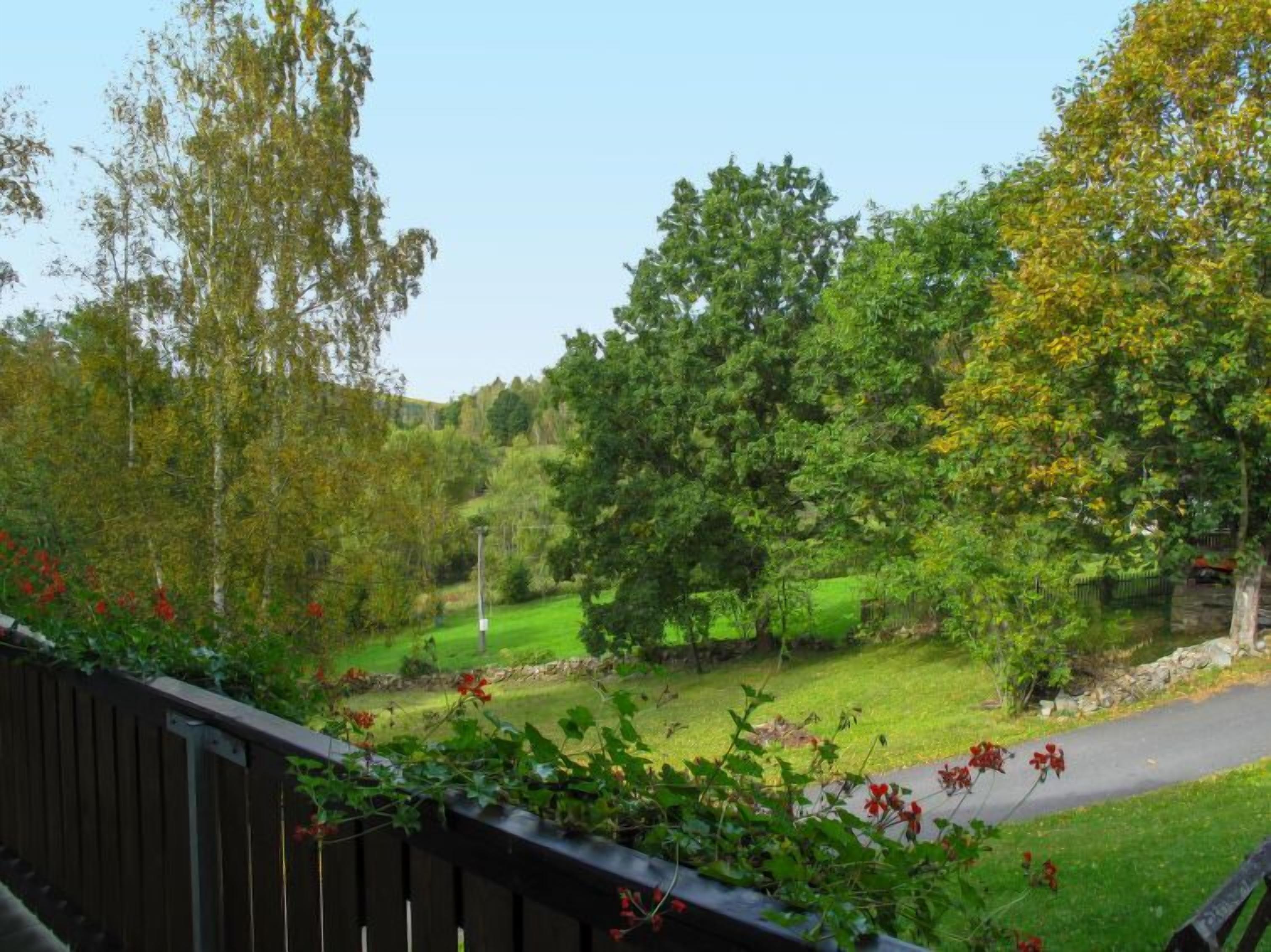 A view of a golf course with a wooden deck in the foreground.
