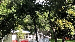 A house with a porch, a covered outdoor seating area, and a small deck. - A Cozy, quiet and most perfect cottage beautifully located on a waterfront cove. (BURNET)