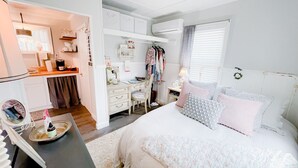 A bedroom with a bed, dresser, vanity, and a small kitchenette area. - A Cozy, quiet and most perfect cottage beautifully located on a waterfront cove. (BURNET)
