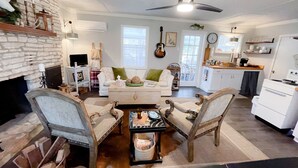 A cozy living room with a fireplace, a dining area, and a kitchen. - A Cozy, quiet and most perfect cottage beautifully located on a waterfront cove. (BURNET)