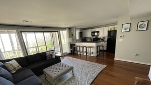 A modern living room with a sofa, ottoman, and patterned rug. - Eagles Court Ski In/Ski Out Condo with Walkable Location & Mountain Views! (Wintergreen Resort)