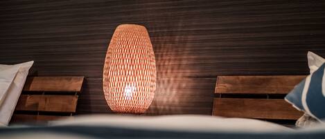 A modern room with a textured wall, a hanging light fixture, and wooden headboards.