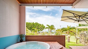 A hot tub in a wooden deck area with a view of a garden and trees.