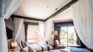 A hotel room with two beds, a balcony, and a view of the outdoors.