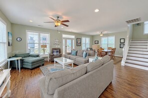 A spacious living room with a sectional sofa, a coffee table, and a dining area with chairs.