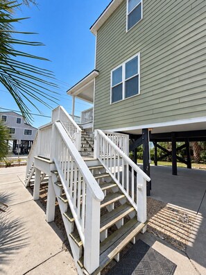 A two-story house with a covered porch and a staircase.