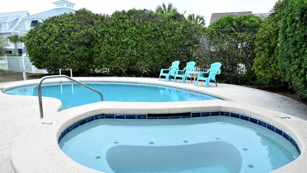 A swimming pool with two hot tubs and three blue chairs. - Swamp Fox (Formerly Footprints) - Second Row in Garden City Beach, SC (Garden City)