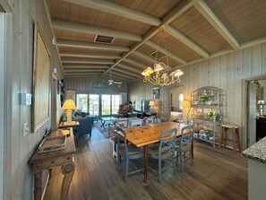 Relax in this spacious room with a dining table, comfortable seating area, and fully equipped kitchen.