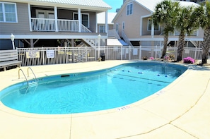 A swimming pool with a white fence, shallow water signs, and a lifeguard sign. - Summer Winds 5 - Second Row complex in Garden City Beach, SC (Garden City Beach)