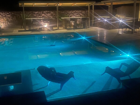 Una piscina con sillas de descanso y zona de barbacoa.