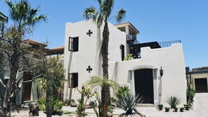 Un bâtiment moderne à deux étages, doté d’une façade blanche, d’un balcon et d’une grande entrée en arc de cercle.