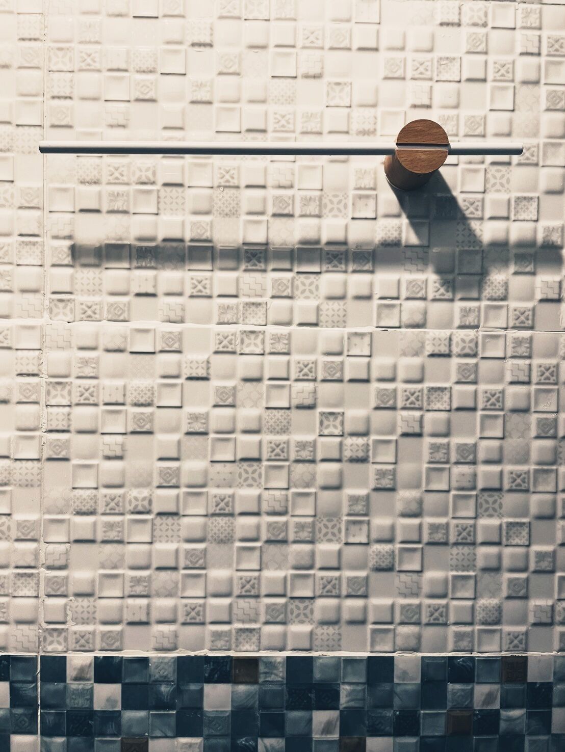 Paredes revestidas com azulejos e um design padronizado, com uma barra horizontal.