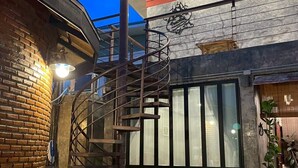 A modern building with a spiral staircase, a brick wall, and a large window.
