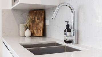 A modern kitchen with a sleek stainless steel faucet, a built-in sink, and a wooden accent wall.