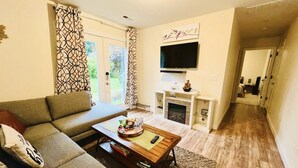 Ein Wohnzimmer mit Sofa, Couchtisch und Kamin.