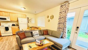 A compact living space with a sofa, coffee table, and kitchen area including a microwave and refrigerator. - Private Guest Suite - near Alderwood Mall - Seattle (Lynnwood)