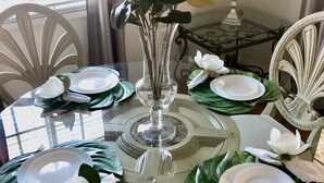 A dining table set with white plates, silverware, and a vase with white flowers. - Cozy Condo in Downtown Long Beach, 2 min walk to the Beach,parking place+garage  (Long Beach)
