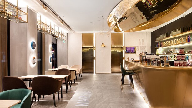 A modern bar area with a curved counter, seating, and a visible elevator. - CITIGO HOUSE Tianhe Guangzhou (Guangzhou)