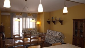 Un comedor con una mesa, sillas, un sofá y un armario.