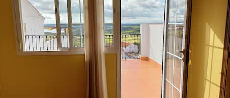 A room with a view of a balcony, a sliding glass door, and a chair.