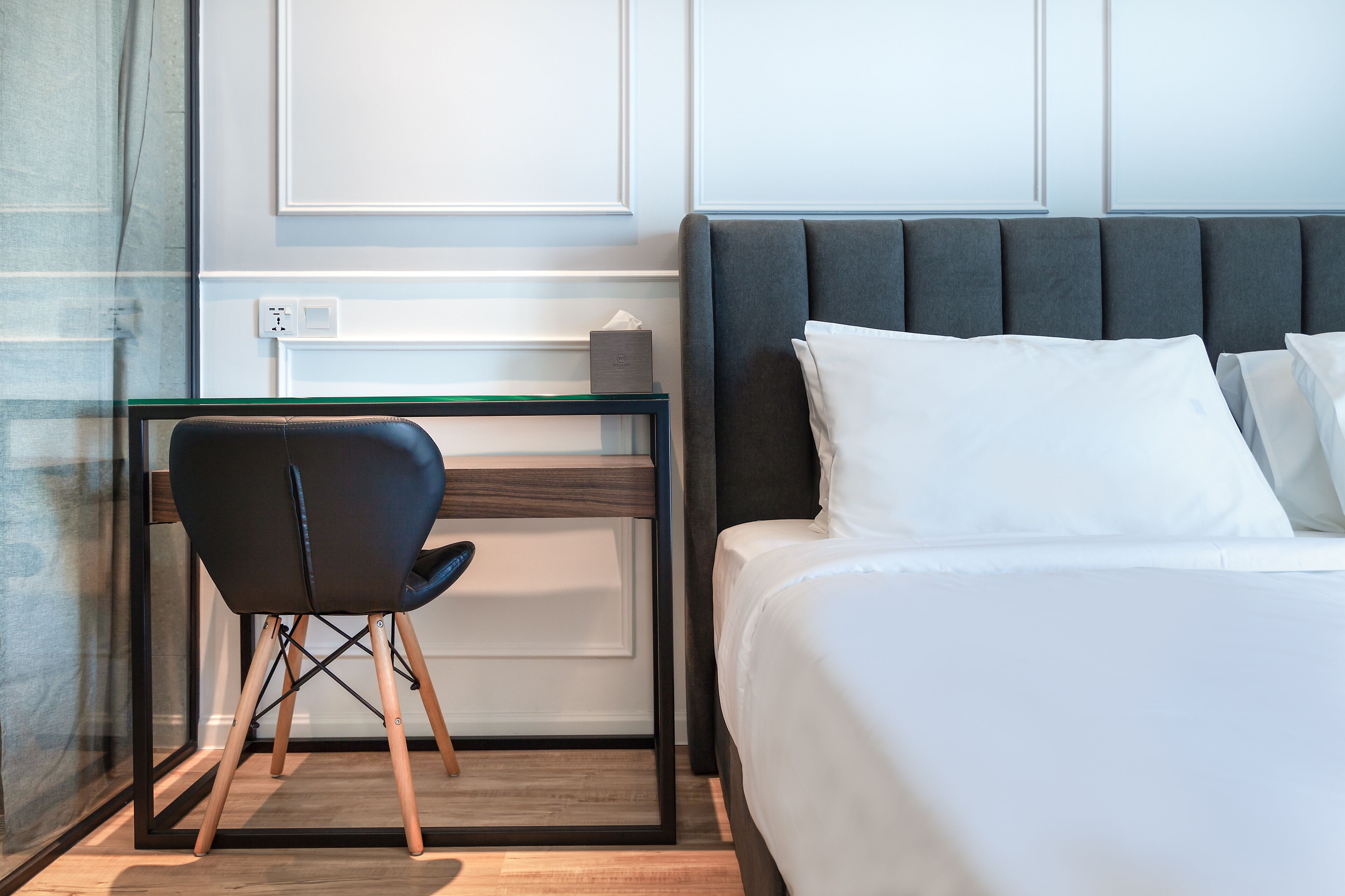 A hotel room with a bed, a desk, and a chair.