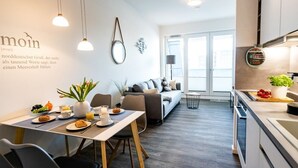 Una cocina moderna con comedor, un sofá y un amplio ventanal.