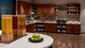 Eine Küche mit Holzausstattung, einer weißen Arbeitsplatte und einer gefliesten Spritzschutzwand.
