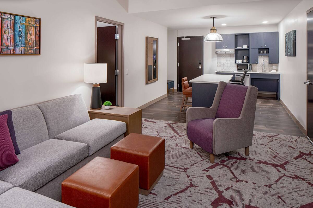 A modern living room with a grey sofa, a purple armchair, and a small coffee table.