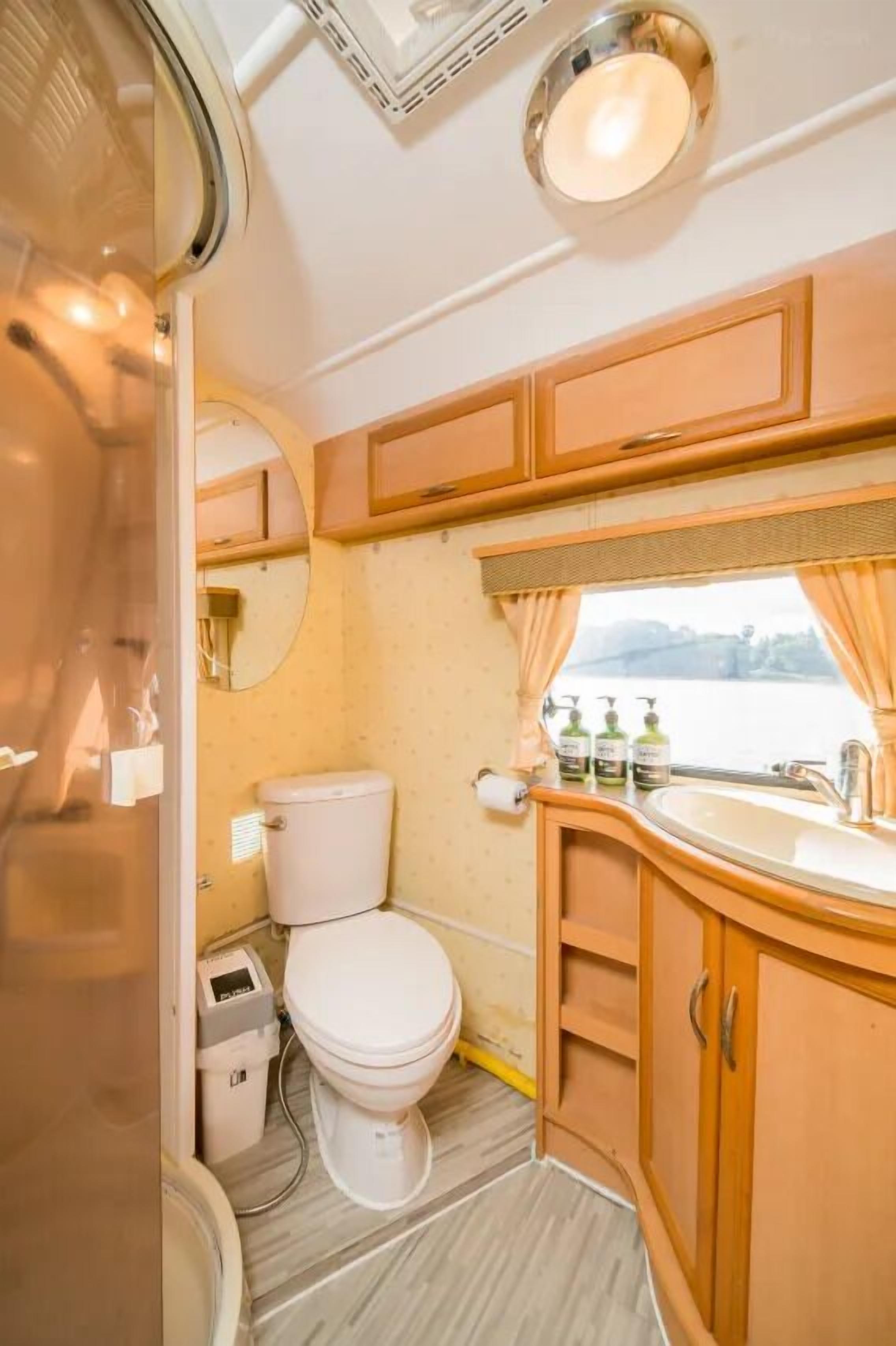 Un baño pequeño con inodoro, lavamanos y espejo.