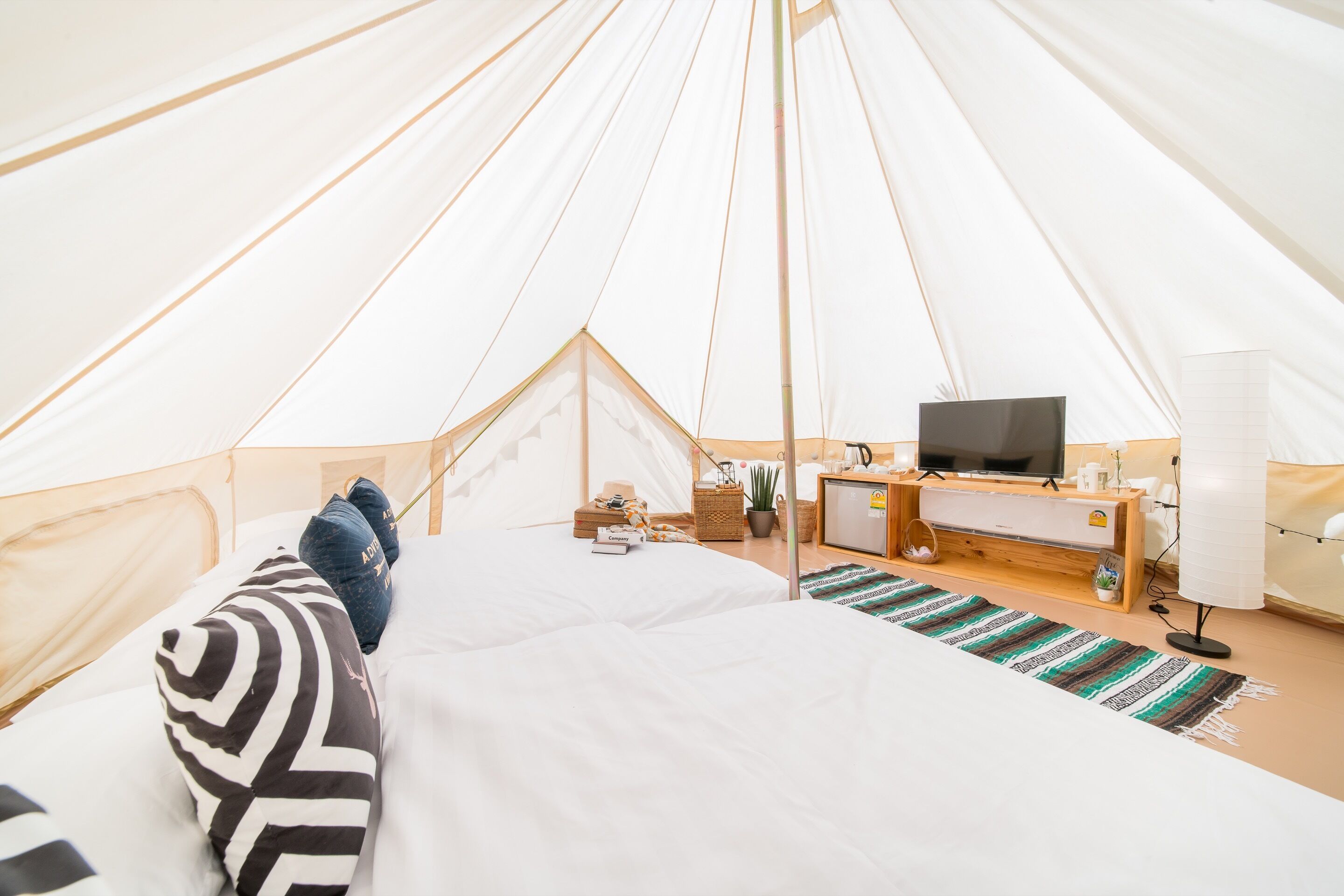Een accommodatie met tent, bed, televisie en bureau.