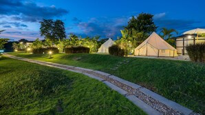 A well-lit outdoor area with a pathway leading to a series of tents.