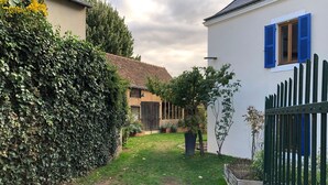Il s’agit d’une propriété résidentielle dotée d’une allée pavée menant à un portail en bois, d’une pelouse bien entretenue et d’une haie.