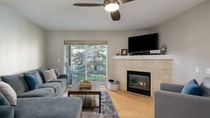 Una sala de estar moderna con un sofá gris, una mesita de centro y una chimenea.