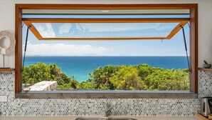 Una cocina con un ventanal que ofrece vistas al mar.