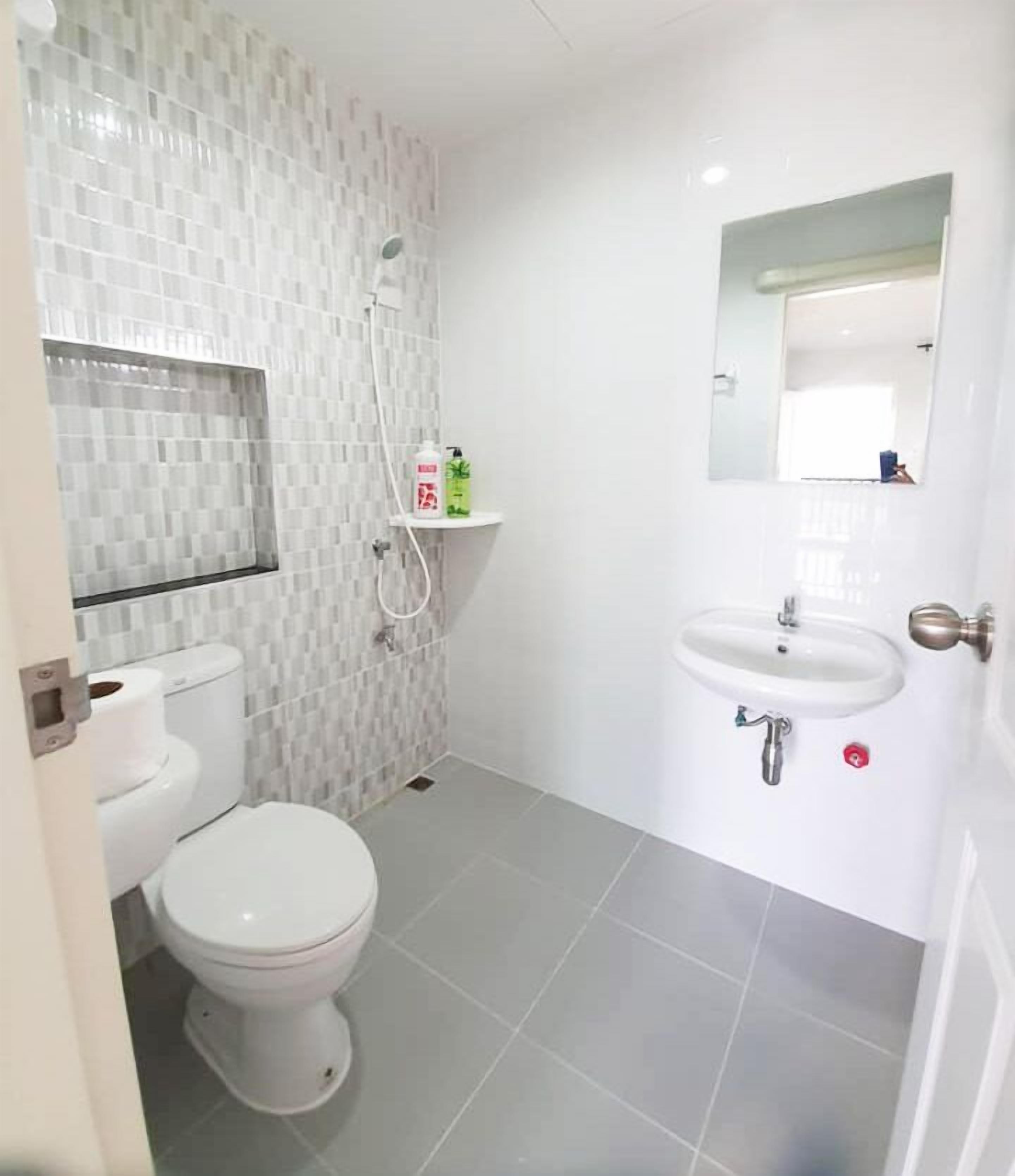 A bathroom with a toilet, a shower, and a sink.
