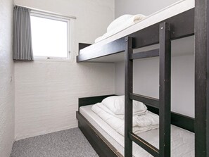A bunk bed room with a window and a curtain.