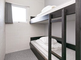 Habitación con literas, una ventana y una cortina.